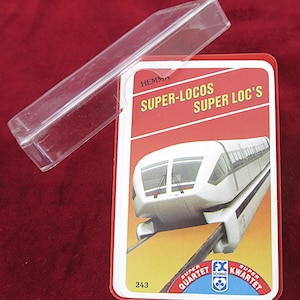 Könnte beinhalten: Eine rot-weiße Kartenspielbox mit einem durchsichtigen Kunststoffdeckel. Die Karten im Inneren zeigen ein futuristisches Zugdesign und den Text "SUPER-LOCOS SUPER LOC'S". Das Spiel trägt die Bezeichnung "SUPER QUARTET".