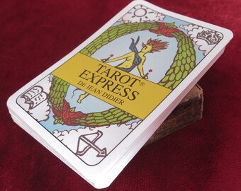May include: A deck of Tarot Express cards by Jean Didier. The card shown is the Empress, featuring a woman in a green wreath with a crown above her head. The card is white with yellow text that reads "Tarot Express De Jean Didier".