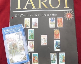May include: A black instructional poster titled Claves y Secretos del TAROT with the subtitle El Tarot de las Presencias and number 42, featuring a layout of tarot cards and the text La Tirada de las Dos Columnas, alongside a blue tarot card deck box.