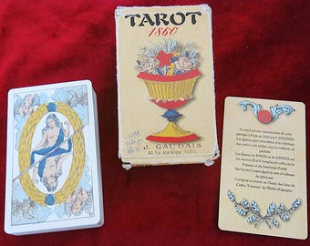 Puede incluir: Una baraja de cartas Tarot 1860, una caja rectangular con una ilustración amarilla de un cáliz lleno de flores y una tarjeta informativa con texto en francés. La caja presenta el texto Tarot 1860 y J. Gaudais 20 Rue de la Banque Paris.