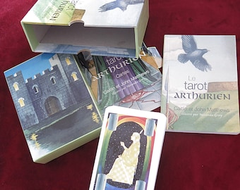 May include: A tarot card set with a light green box featuring the text "tarot Arthurien" and a bird illustration. The set includes cards and a book titled "Le tarot Arthurien" with illustrations by Miranda Gray.