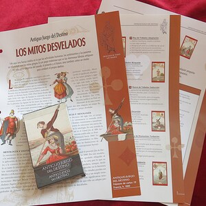 May include: A set of printed materials, including a card deck and several pages with text and illustrations. The card deck has a vintage design with figures in period clothing. The pages contain text in Spanish and illustrations.