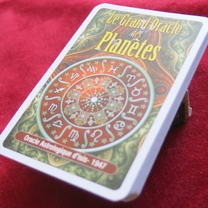 May include: A deck of cards with a colorful design featuring a circular pattern of astrological symbols and the text "Le Grand Oracle des Planetes" and "Oracle Astrologique d'Isis - 1947".