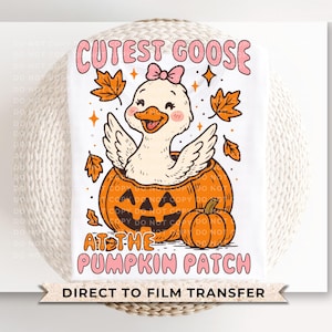 May include: A white t-shirt featuring a cartoon goose with a pink bow sitting inside an orange pumpkin. The text "Cutest Goose at the Pumpkin Patch" is above and below the goose. Autumn leaves and stars are also included.