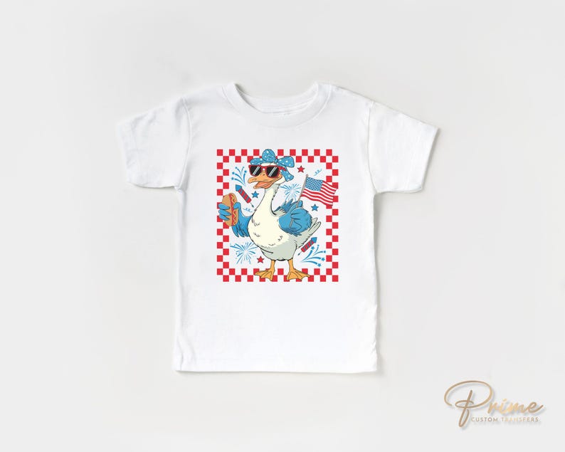 May include: White t-shirt with a graphic of a goose wearing sunglasses and a bandana, holding a hot dog and a small American flag. The goose is standing on a red and white checkered background.