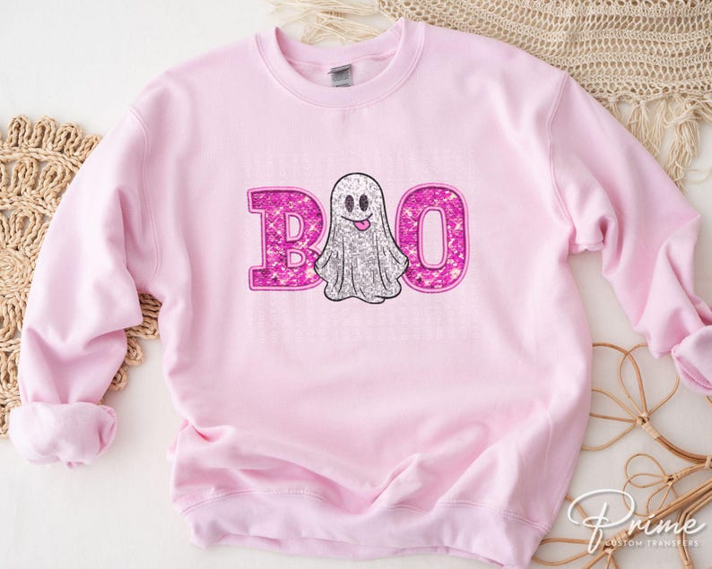 May include: Pink sweatshirt with a sparkly pink ghost and the word "BOO" in sparkly pink letters.