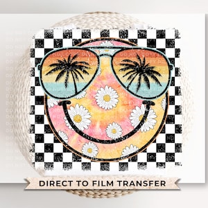 May include: A yellow smiley face with sunglasses and a floral pattern on a black and white checkered background. The sunglasses have a blue and pink gradient with palm trees reflected in the lenses. The text "DIRECT TO FILM TRANSFER" is at the bottom of the image.