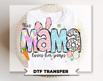 May include: White t-shirt with the words "this MAMA loves her peeps" in colorful, whimsical lettering. The design includes bunny ears, a carrot, and Easter eggs, perfect for the spring season. The shirt is a DTF transfer.