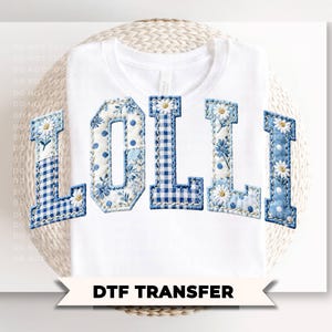 May include: White t-shirt with the word "LOLLI" in blue and white floral and gingham patterned letters. The letters are appliqued onto the shirt. The text "DTF TRANSFER" is below the shirt.