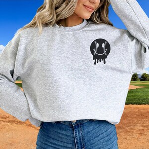 A direct to film transfer that says Somebody's Loud mouth Softball Mom. Back and front option. Front design is of baseball smiley face. The DTF transfer is a cold peel ready to press transfer.