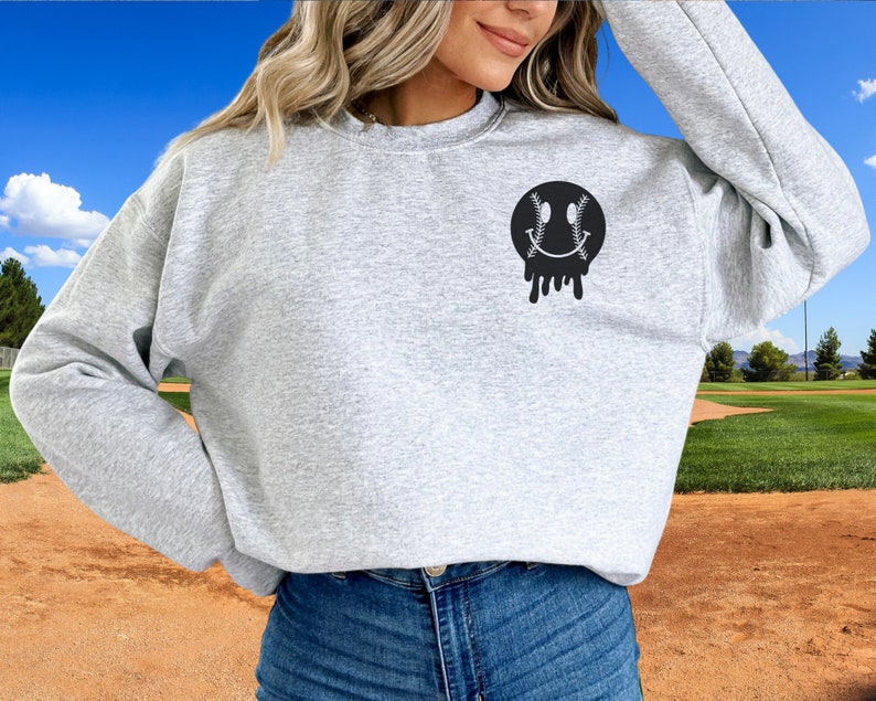 A direct to film transfer that says Somebody's Loud mouth Softball Mom. Back and front option. Front design is of baseball smiley face. The DTF transfer is a cold peel ready to press transfer.