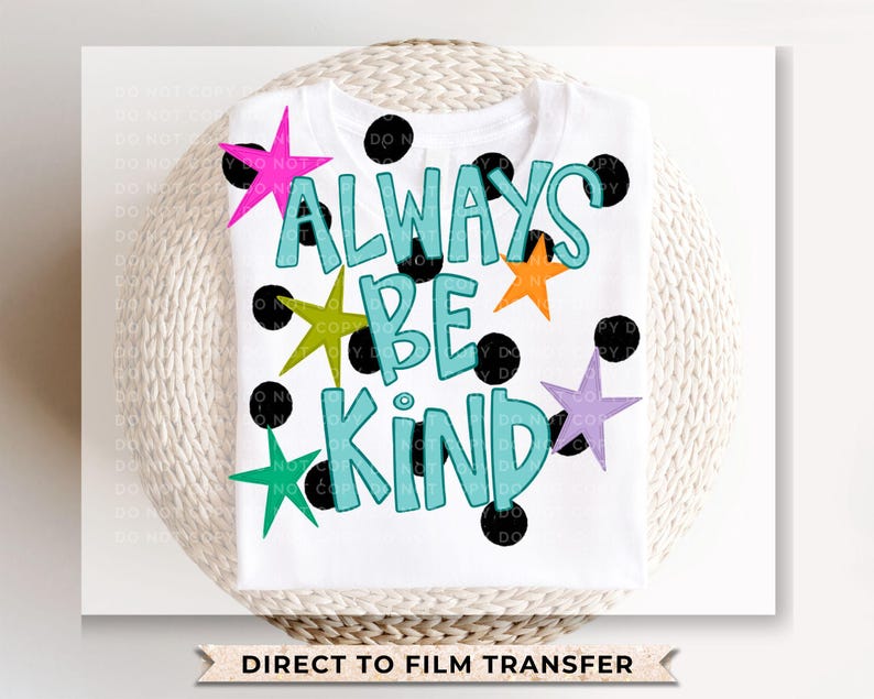 May include: White t-shirt featuring the phrase "ALWAYS BE KIND" in turquoise, with black outlines. The design includes colorful stars and black polka dots. The words "DIRECT TO FILM TRANSFER" are at the bottom.