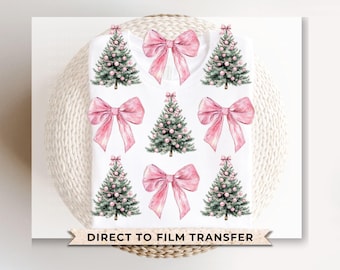May include: A white t-shirt with a pink bow and watercolor Christmas tree design. The text "Direct to Film Transfer" is printed at the bottom of the shirt.