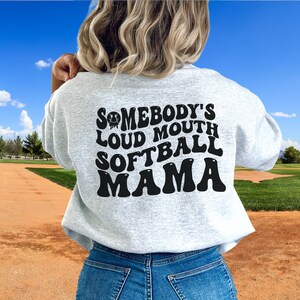 A direct to film transfer that says Somebody's Loud mouth Softball Mom. Back and front option. Front design is of baseball smiley face. The DTF transfer is a cold peel ready to press transfer.