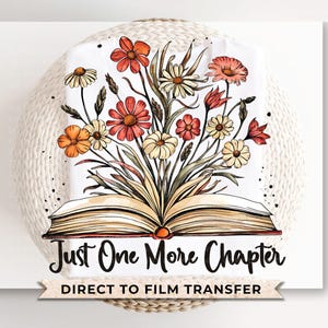 May include: A white t-shirt with a watercolor illustration of an open book with flowers spilling out of it. The text "Just One More Chapter" is printed below the book. The text "Direct to Film Transfer" is printed below the text.