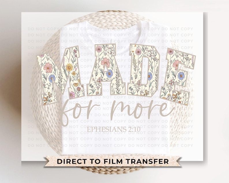Puede incluir: Camiseta blanca con las palabras "MADE for more" en un dise&ntilde;o floral. El texto "Ephesians 2:10" est&aacute; debajo del texto principal. Las palabras "DIRECT TO FILM TRANSFER" est&aacute;n en la parte inferior.