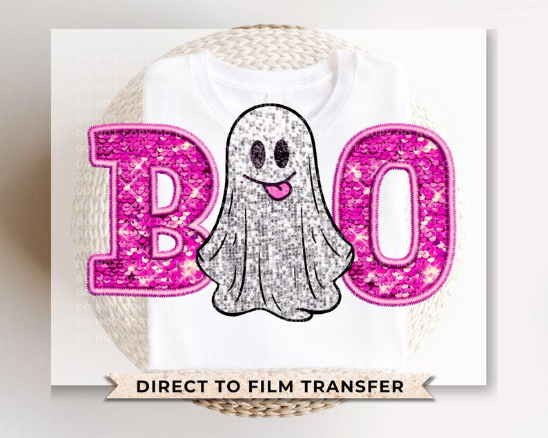 May include: A white t-shirt with a pink sparkly "BOO" and a ghost graphic. The ghost is white with a pink mouth and eyes. The text "DIRECT TO FILM TRANSFER" is at the bottom of the shirt.