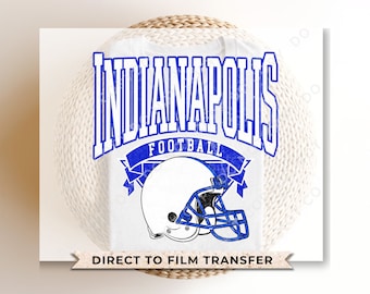May include: White t-shirt featuring a blue and white graphic design that reads "Indianapolis Football" with a football helmet graphic. The text "Direct to Film Transfer" is printed at the bottom of the shirt.