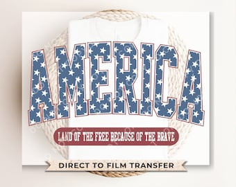 May include: A white t-shirt with a blue and red "America" graphic featuring white stars. The text "Land of the Free Because of the Brave" is below the graphic. The text "Direct to Film Transfer" is at the bottom of the shirt.