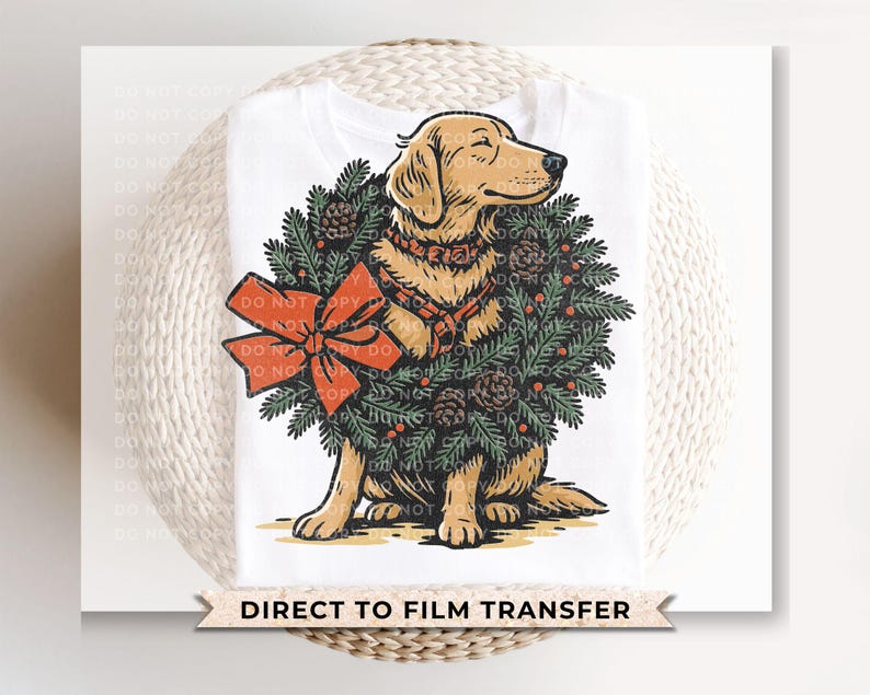 May include: White t-shirt featuring a golden retriever dog wearing a Christmas wreath with a red bow. The dog is sitting, and the wreath includes pinecones and berries. The text "DIRECT TO FILM TRANSFER" is at the bottom.
