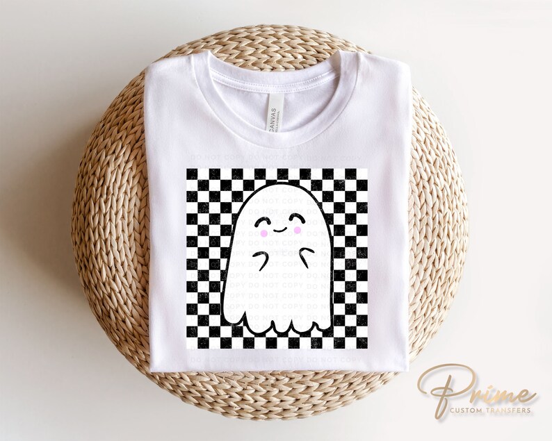 May include: White t-shirt with a black and white checkered pattern and a cute ghost with pink cheeks in the center.