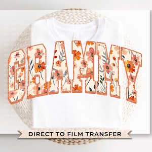 May include: White t-shirt with a floral design that spells out "GRAMMY" in orange and brown. The text says "DIRECT TO FILM TRANSFER" at the bottom.