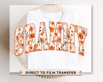 May include: White t-shirt with a floral design that spells out "GRAMMY" in orange and brown. The text says "DIRECT TO FILM TRANSFER" at the bottom.