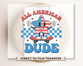 May include: A white t-shirt featuring a red, white and blue star character skateboarding. The star character has a peace sign with each hand. The text "ALL AMERICAN DUDE" is in red and blue letters around the star character. The text "DIRECT TO FILM TRANSFER" is at the bottom of the shirt.