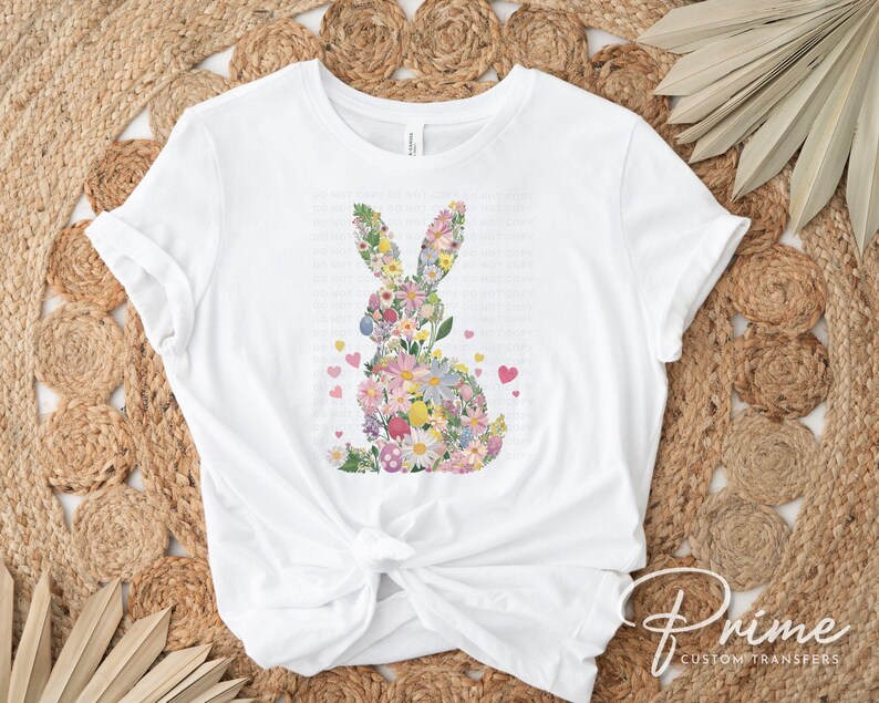 Op de afbeelding: Wit T-shirt met een bloemig konijnontwerp. Het konijn is gemaakt van kleurrijke bloemen en bladeren.