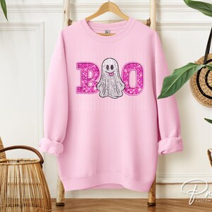 May include: Pink sweatshirt with a sparkly pink "BOO" and a white ghost with a pink smile.