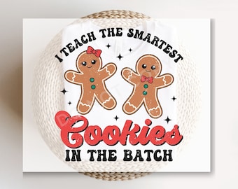 May include: White onesie with a red, black, and green gingerbread cookie graphic. The text reads "I teach the smartest cookies in the batch".