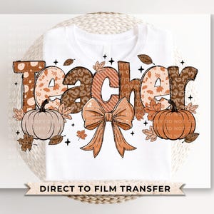 May include: White t-shirt with the word "TEACHER" in a fall-themed design. The letters feature leopard print, floral patterns, and a bow. Pumpkins and leaves are also included in the design. The text "DIRECT TO FILM TRANSFER" is at the bottom.