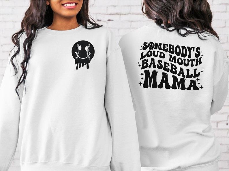 May include: White sweatshirt with a black baseball-themed smiley face on the front and the text "Somebody's Loud Mouth Baseball Mama" on the back.