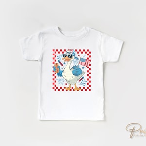K&ouml;nnte beinhalten: Wei&szlig;es T-Shirt mit einem rot-wei&szlig;-blauen karierten Hintergrund. Eine Cartoon-Gans mit Sonnenbrille und einem rot-wei&szlig;-blauen Hut h&auml;lt einen Hotdog und eine kleine amerikanische Flagge. Der Text "Prime Custom Transfers" befindet sich in der rechten unteren Ecke.