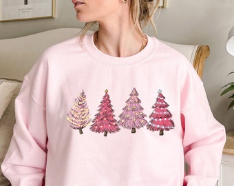 May include: Pink sweatshirt with a graphic of five pink Christmas trees with white lights and stars on a pink background.