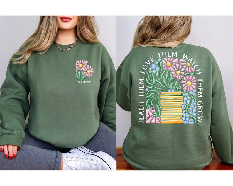 May include: Green sweatshirt with a floral design on the front and back. The front features two pink and yellow flowers with the text "Ms. Smith". The back has a vase of flowers and the text "TEACH THEM, LOVE THEM, WATCH THEM GROW."