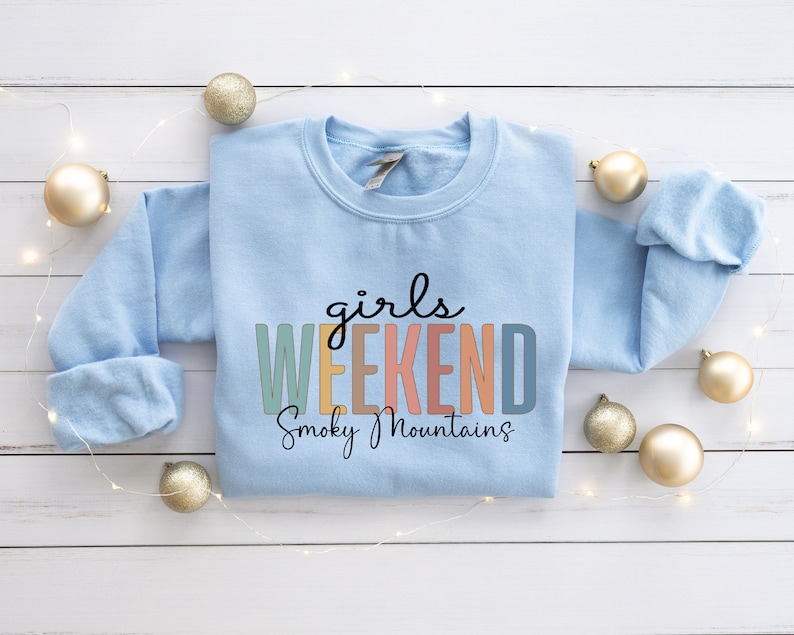 Peut inclure: Sweat-shirt bleu clair avec le texte "girls weekend Smoky Mountains" en lettres color&eacute;es.