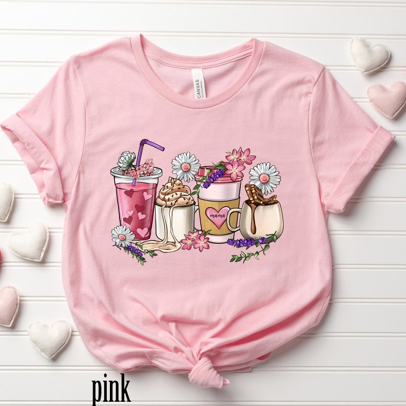 Pode incluir: Camiseta rosa com um gr&aacute;fico de cinco bebidas de caf&eacute; diferentes com flores e a palavra "mama" em uma das x&iacute;caras.