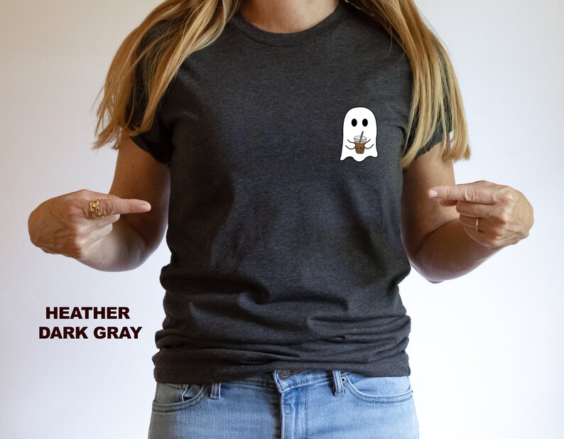 Puede incluir: Una camiseta gris oscuro jaspeada con un fantasma blanco que sostiene una taza de caf&eacute; helado marr&oacute;n. El texto "HEATHER DARK GRAY" est&aacute; impreso debajo de la imagen.