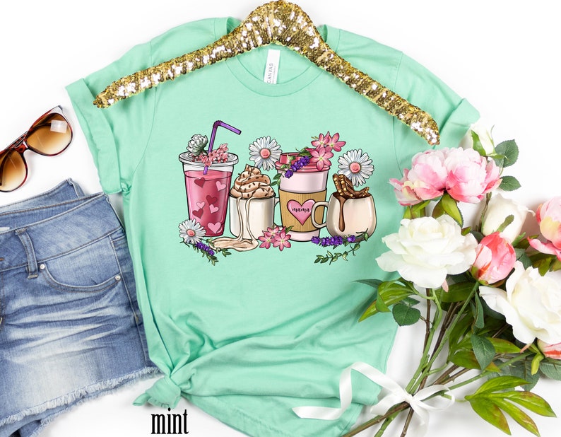 Pode incluir: Camiseta verde menta com um gr&aacute;fico de caf&eacute;, chocolate quente e um latte com flores e a palavra "morning" na x&iacute;cara de caf&eacute;.