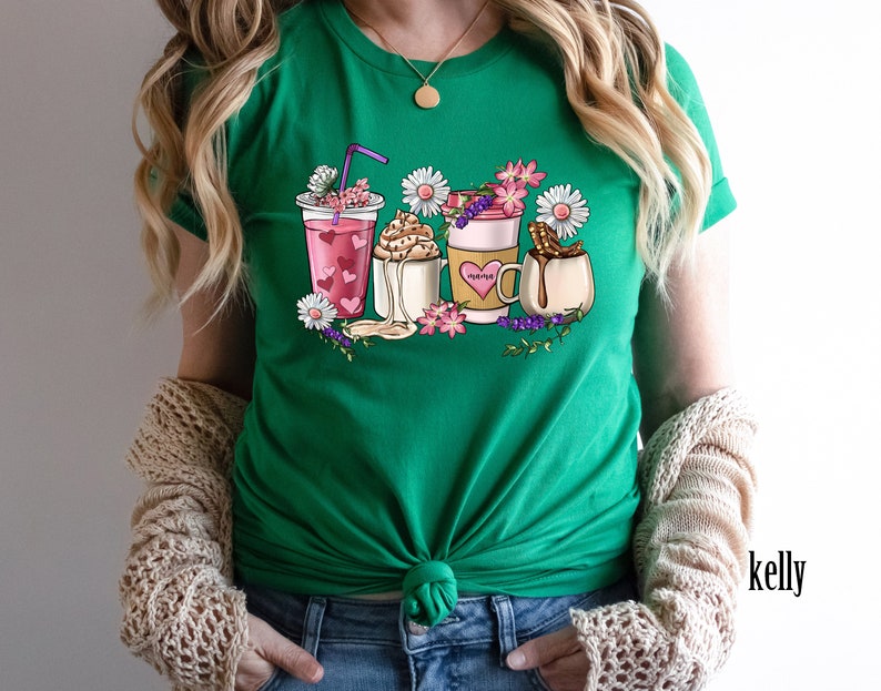 Pode incluir: Camiseta verde com um gr&aacute;fico de v&aacute;rias bebidas de caf&eacute; e ch&aacute; com flores e a palavra "morning" em uma das x&iacute;caras.
