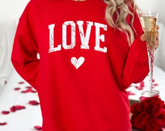 May include: Red sweatshirt with a white "LOVE" graphic and a small white heart.