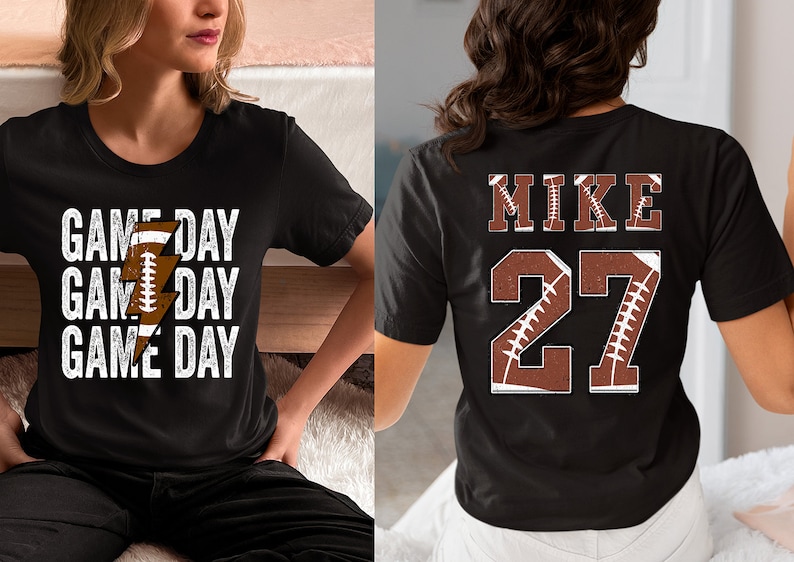 May include: Two black t-shirts with a football theme. One shirt has the text "GAME DAY" repeated three times with a lightning bolt and football graphic. The other shirt has the text "MIKE 27" with a football graphic.