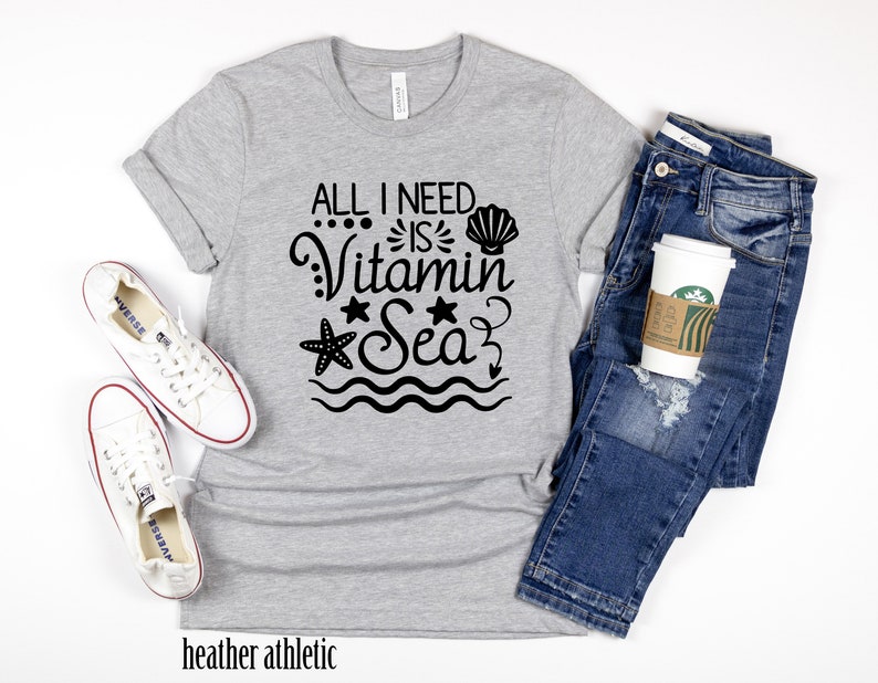 May include: Grey heather athletic t-shirt with black text that reads "All I need is Vitamin Sea" with a seashell, starfish, and waves.