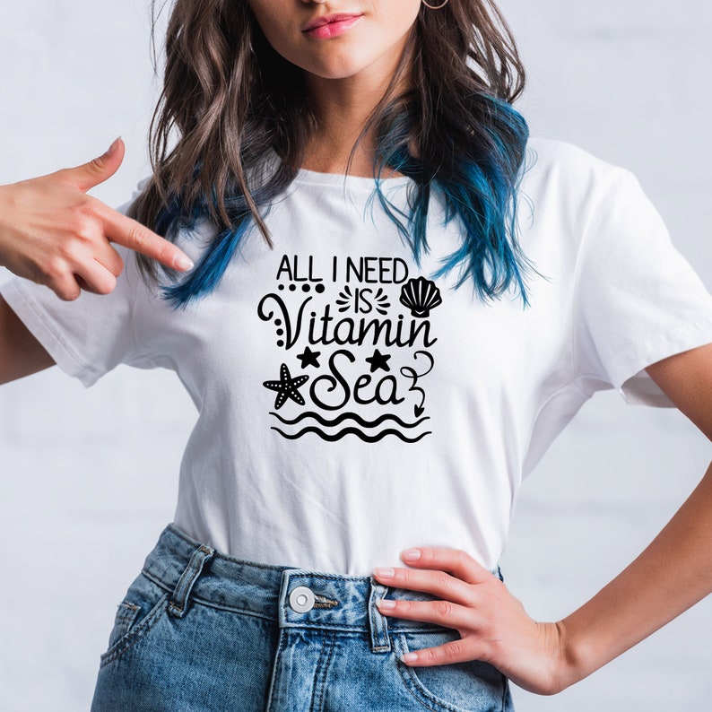 May include: White t-shirt with a black graphic that says "All I need is Vitamin Sea". The graphic includes a seashell, a starfish, and a wave.