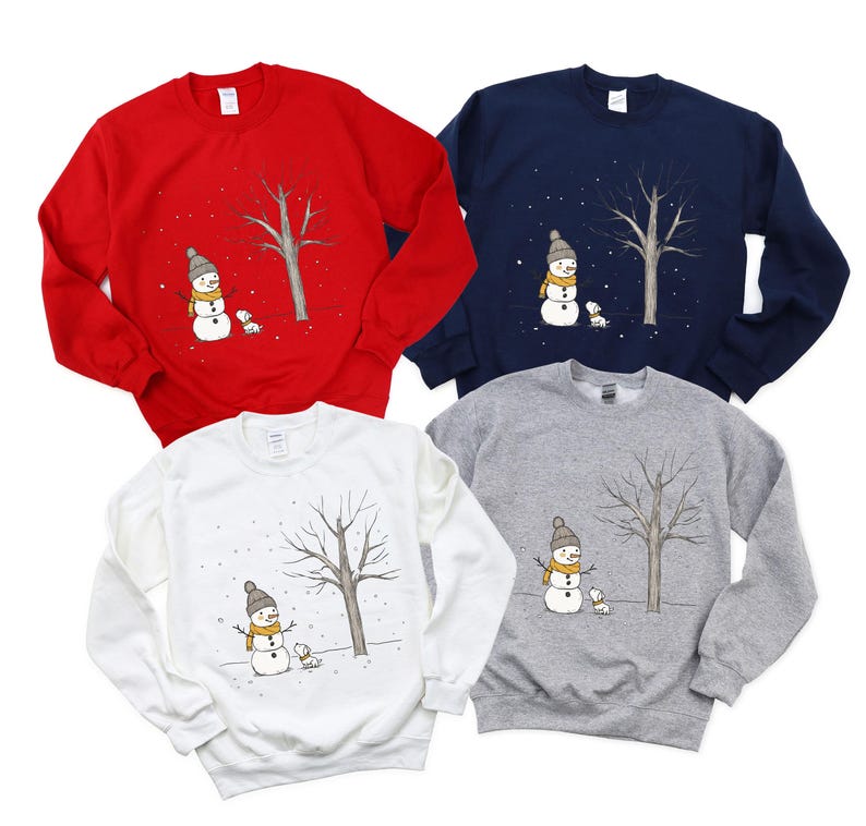May include: Four different coloured sweatshirts with a snowman and a dog design. The sweatshirts are red, navy blue, white and grey.