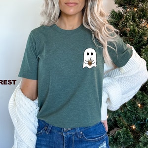 Puede incluir: Una camiseta verde con un gr&aacute;fico de fantasma blanco sosteniendo una taza de caf&eacute;. El fantasma tiene dos ojos y una peque&ntilde;a sonrisa. La camiseta est&aacute; hecha de un material suave y c&oacute;modo.