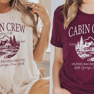 May include: A cream t-shirt and a maroon t-shirt, each featuring a graphic of a cabin in the woods with the text CABIN CREW, before I do, JULY 2025, OLIVIA'S BACHELORETTE, and Lake George, New York printed in a circular design on the front.