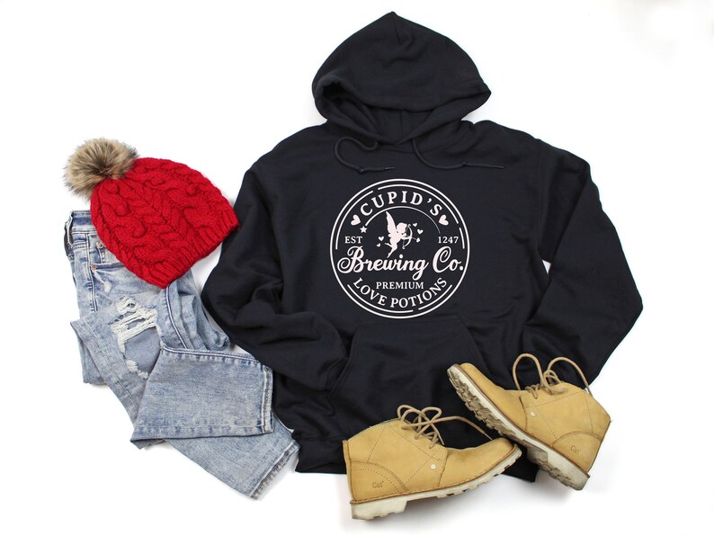 May include: Black hoodie with a white graphic of a cupid with a heart and arrow, and the text "Cupid's Brewing Co. Est. 1247 Premium Love Potions".