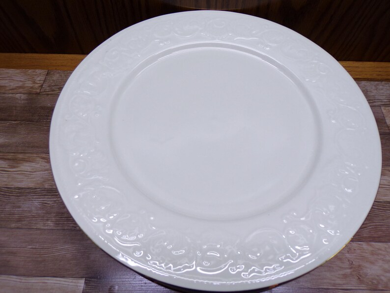 Pu&ograve; includere: Un piatto da cena in ceramica bianca con un motivo floreale decorativo in rilievo sul bordo. Il piatto &egrave; rotondo e ha una superficie liscia e lucida. Il piatto misura circa 30 cm di diametro.